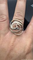 Front view of sterling silver swirl wrap ring on display finger