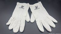 Both white cotton gloves with Swarovski logo visible