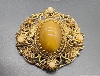 Front view showing cabochon, pearls, rhinestones, filigree