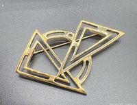 Front view of gold-tone abstract geometric brooch
