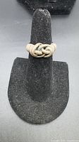 Front view of sterling silver knot ring on display stand