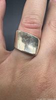 Front view of sterling silver wide concave band ring on finger