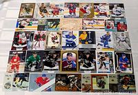 Full lot view of 31 hockey cards laid out in rows