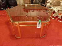 Angled front view showing brass frame and smoked glass top