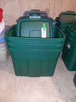 Front view of three stacked green Rubbermaid ECOSense totes with lids