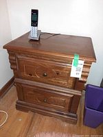Front and top view of wooden nightstand showing two drawers and brass-tone knobs
