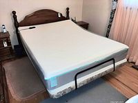 Full view of queen mattress on adjustable base with wood headboard