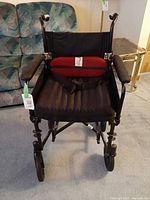 Front view of Airgo Comfort-Plus transport chair with seatbelt and footrest mounts visible