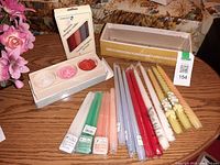 All candles grouped on table: boxed rose candles, Ambiance box, loose tapers