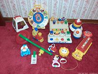Full lot showing all eleven baby toys on carpet