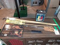 Lot overview with citronella candles, bamboo torch, grill basket, skewers, condiment set