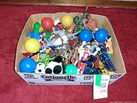 Entire Cottonelle box filled with assorted toys on red carpet