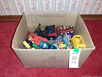 Overview of open box showing many small toy vehicles inside