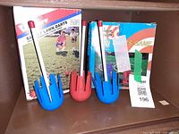 Shelf showing both boxed lawn dart sets and three loose plastic darts