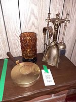 All items together: brass fireplace tool set, amber glass candle holder, brass bed warmer