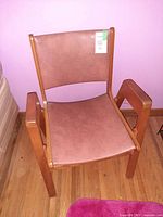 Front view of rose pink vinyl and wood armchair