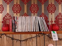 Full view of magazines flanked by red candles on shelf
