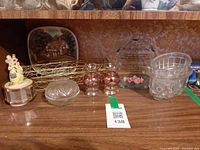 Shelf view showing plate, glass items, figurine, wire basket, plaque