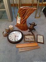 All items grouped: carved vase, clock, prints, metal sculpture, candles, incense