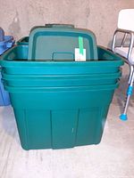 Front view showing two stacked green Rubbermaid totes with one lid visible