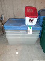 Stack of two Sterilite clear boxes with blue lids, red and white baskets nested on top