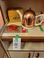 Teapot, egg slicer in package, recipe box on shelf