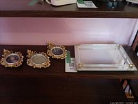 Tray and three frames on shelf