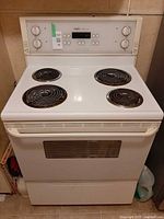 Front view of white Inglis electric range showing four coil burners, control panel and oven door