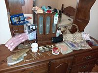 Full view of dresser top with armoire, jewelry, handbags, hangers and accessories