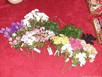 Overview of assorted faux floral bunches on red carpet
