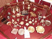 Overview of all brass and copper miniatures displayed on glass table