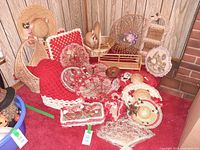 Overall view of wicker baskets, crochet pillows, hats, doilies on red carpet