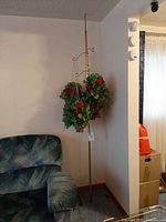 Full view of brass tension pole plant stand with hanging faux plants