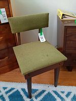 Front angled view of Singer sewing chair showing green tweed upholstery and wood frame