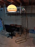 Full view of arc floor lamp beside desk