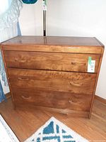 Front view of walnut chest showing three drawers and overall condition
