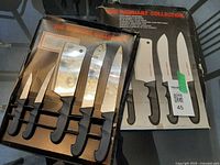 Closed box and open tray displaying five knives