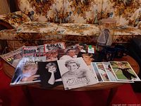 Tabletop view of entire lot showing magazines, mugs and doll
