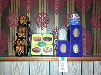 Group shot of tall carved candle, candle tarts box, stacked blue boxes with sculpted candles