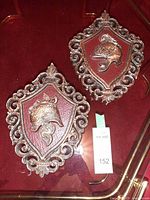 Both Dart Industries shield plaques on red surface with lot tag visible