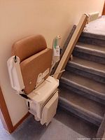 Side view of folded stairlift attached to staircase