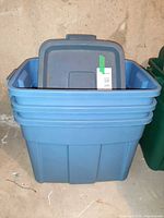 Stack of three blue Rubbermaid Roughneck totes with lids