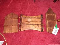 Three wooden spoon racks laid out on carpet