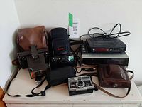 Full lot overview showing all cameras, alarm clocks, and cases