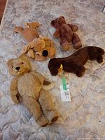 All four plush toys laid out on mattress