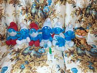 All seven plush toys lined on floral sofa