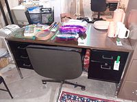 Front view of desk with chair, showing drawers and surface