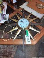Full clock on table showing starburst rays, cord and plug visible