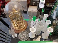 All items including clock, milk glass vases, clear vases, flower frog on table
