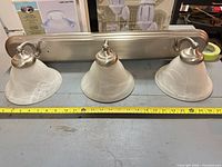 Front view of brushed nickel 3-light vanity fixture with alabaster glass shades